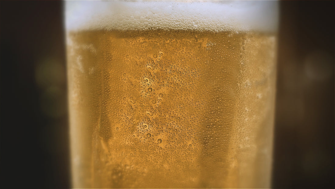 Close-up video of a golden beer with thick foam in a glass, featuring sparkling light effects running through it. A visually appealing showcase of fresh, carbonated beer. Made with WHC Lab bbrewing yeast.